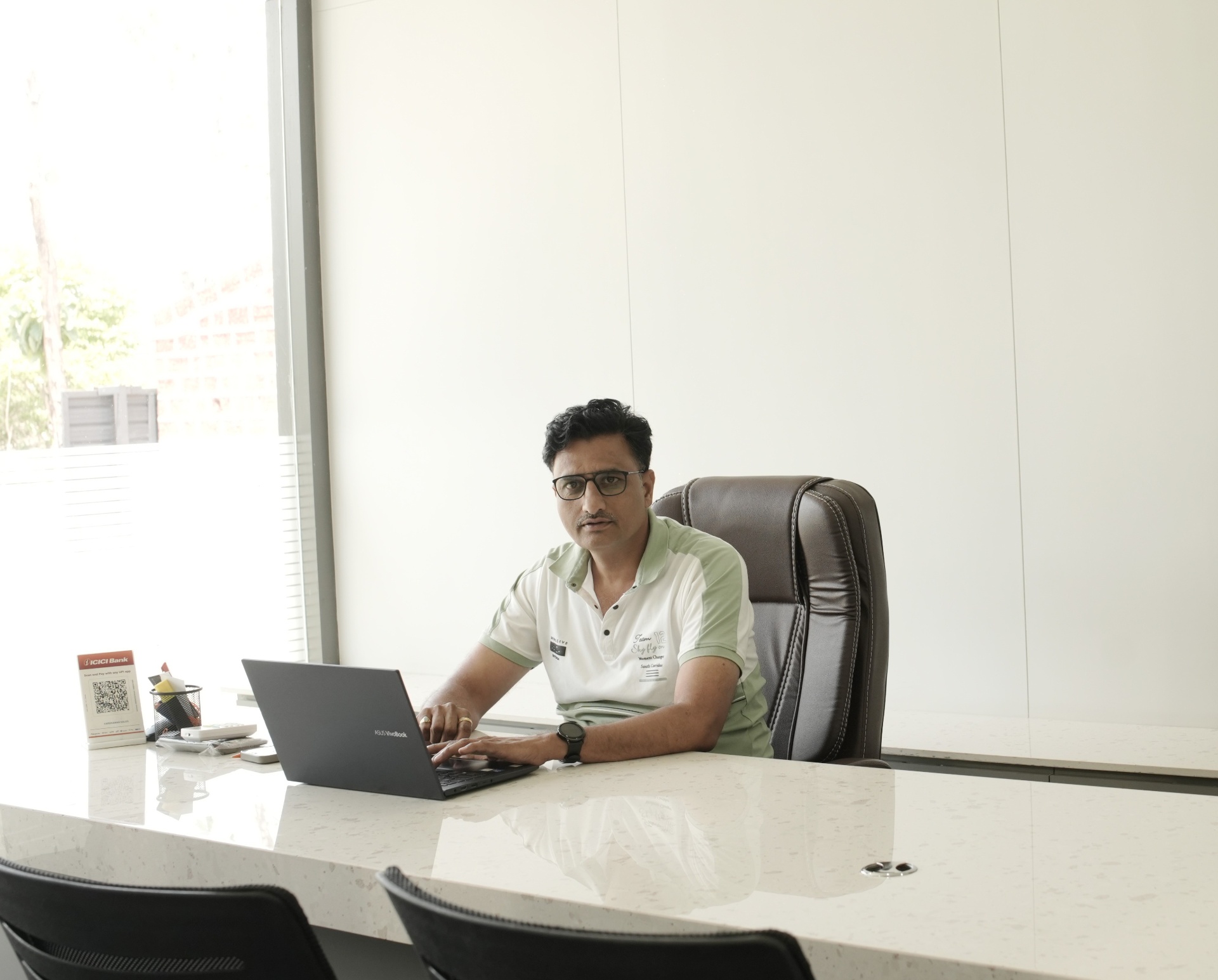 Dr Satish Chougule, Proprietor of Vardhaman Sales, at his desk in the Madabhavi showroom